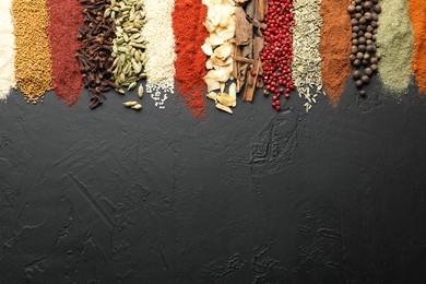 Photo of Many different spices on black table, flat lay. Space for text