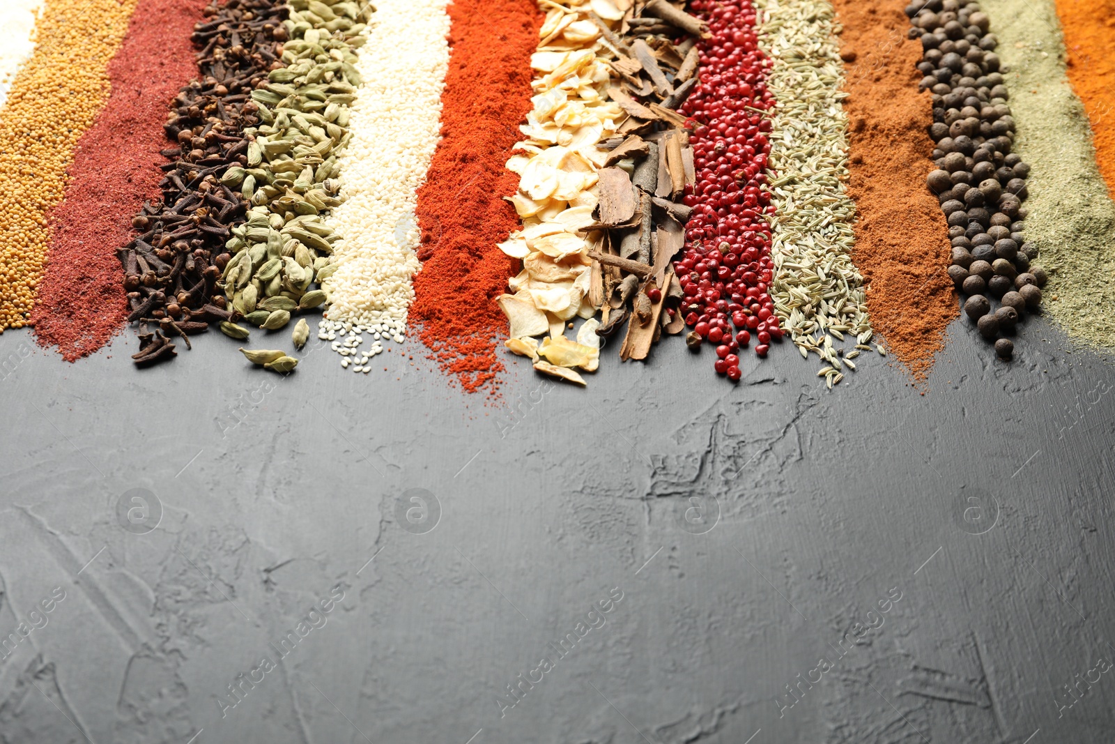 Many different spices on black table, closeup. Space for text Photo of Many different spices on black table, closeup. Space for text
