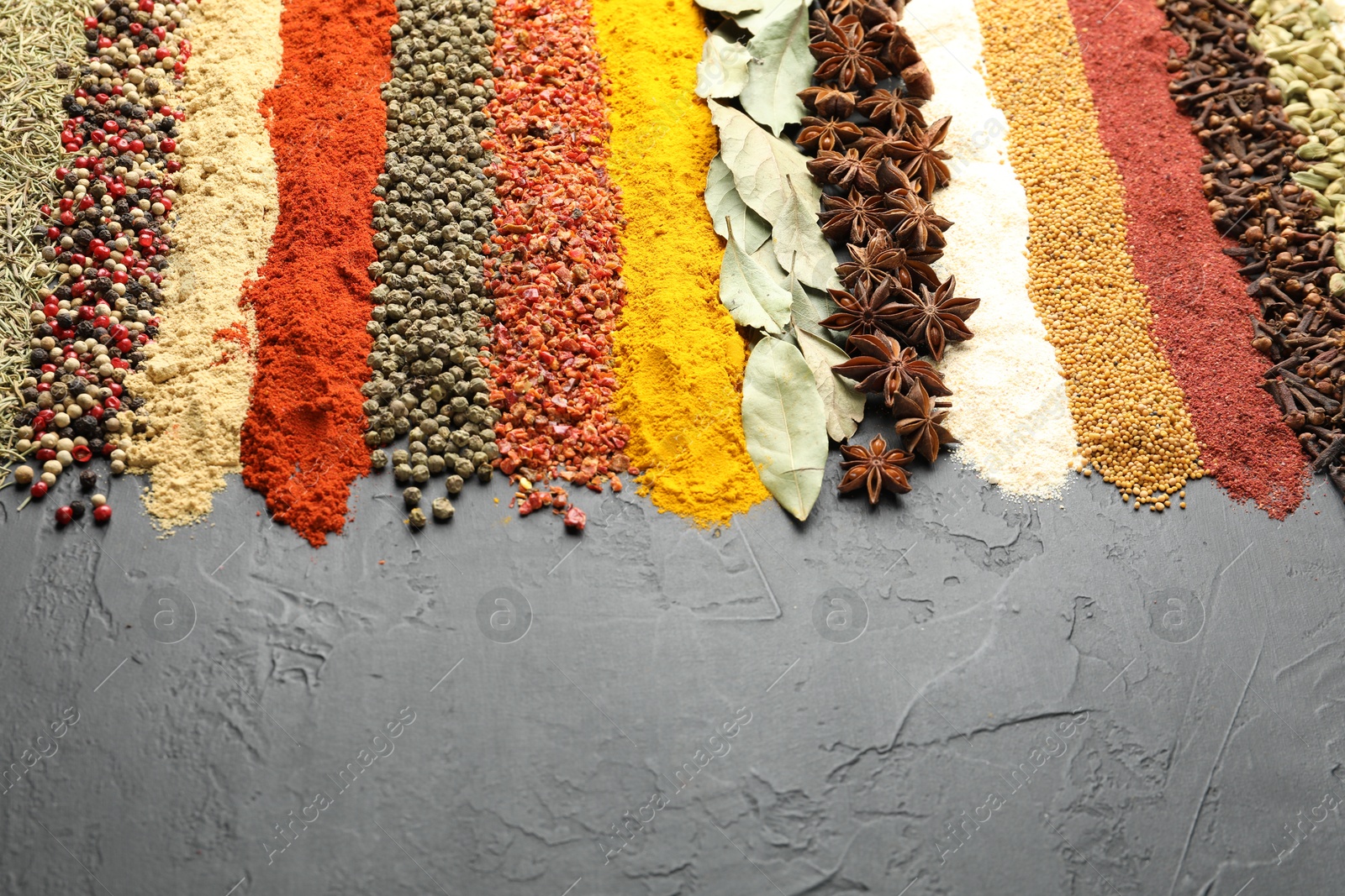 Many different spices on black table, closeup. Space for text Photo of Many different spices on black table, closeup. Space for text