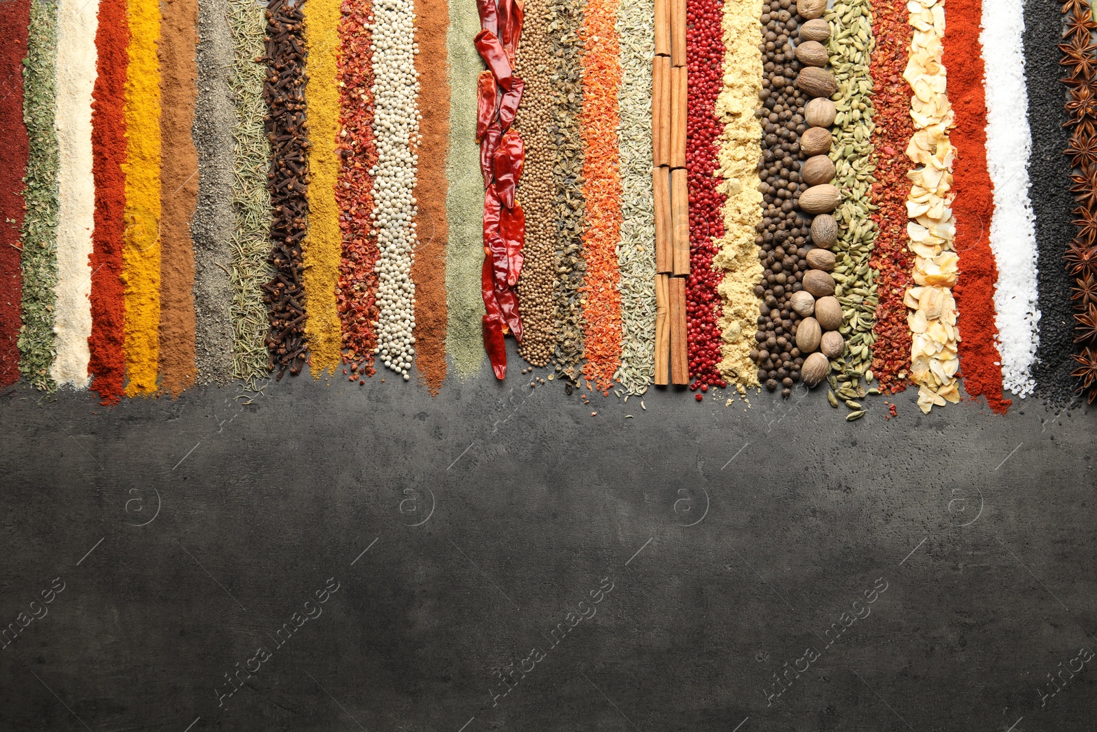 Many different spices on black table, flat lay. Space for text Photo of Many different spices on black table, flat lay. Space for text