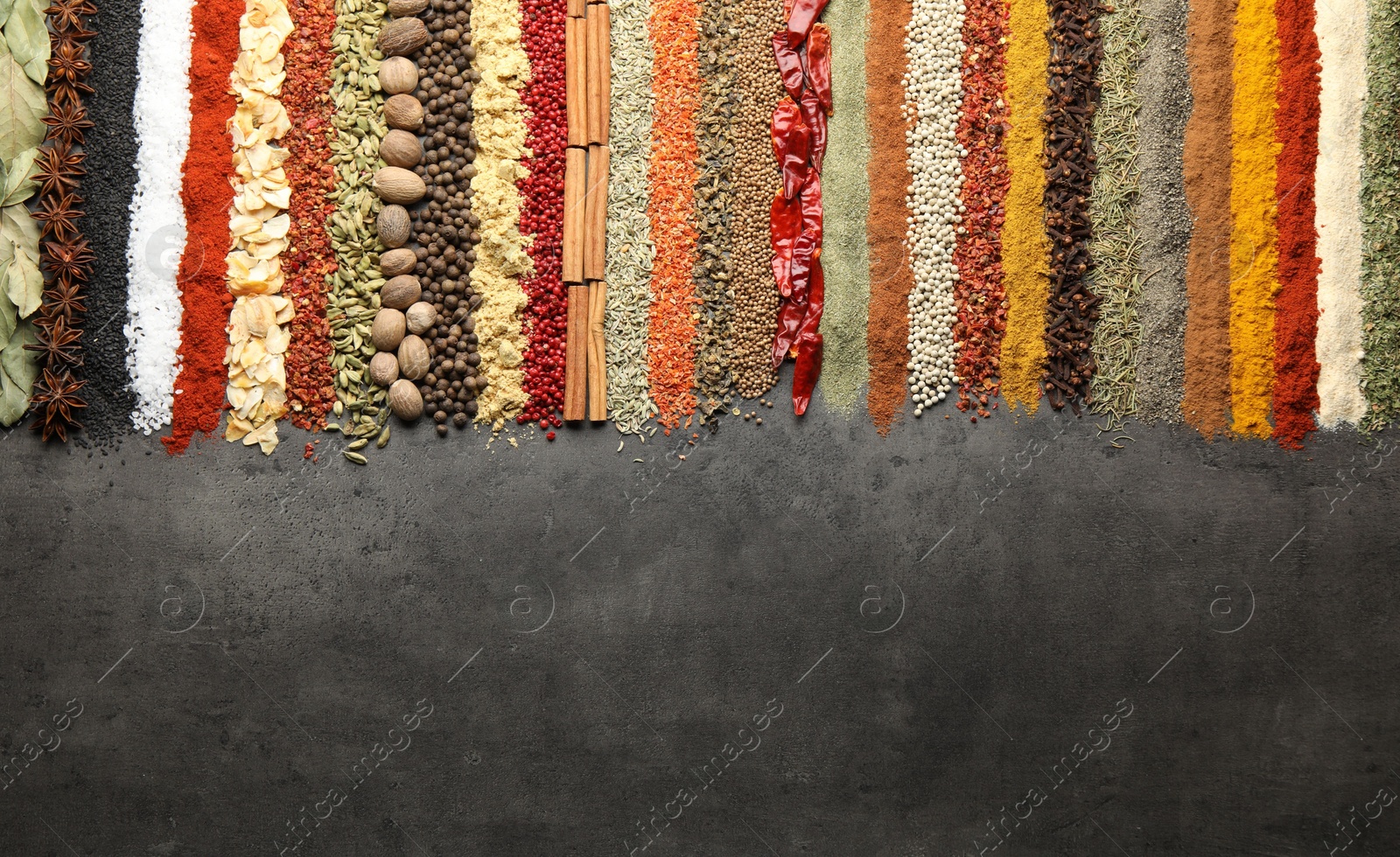 Many different spices on black table, flat lay. Space for text Photo of Many different spices on black table, flat lay. Space for text