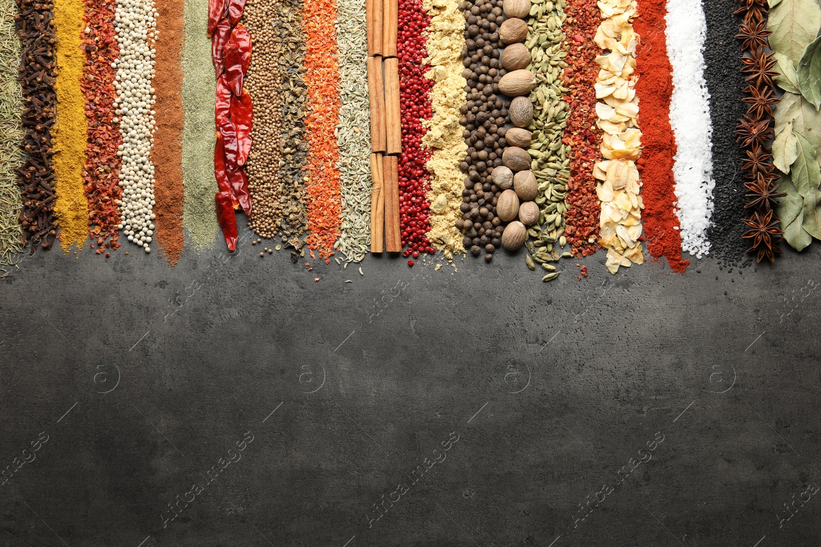 Many different spices on black table, flat lay. Space for text Photo of Many different spices on black table, flat lay. Space for text