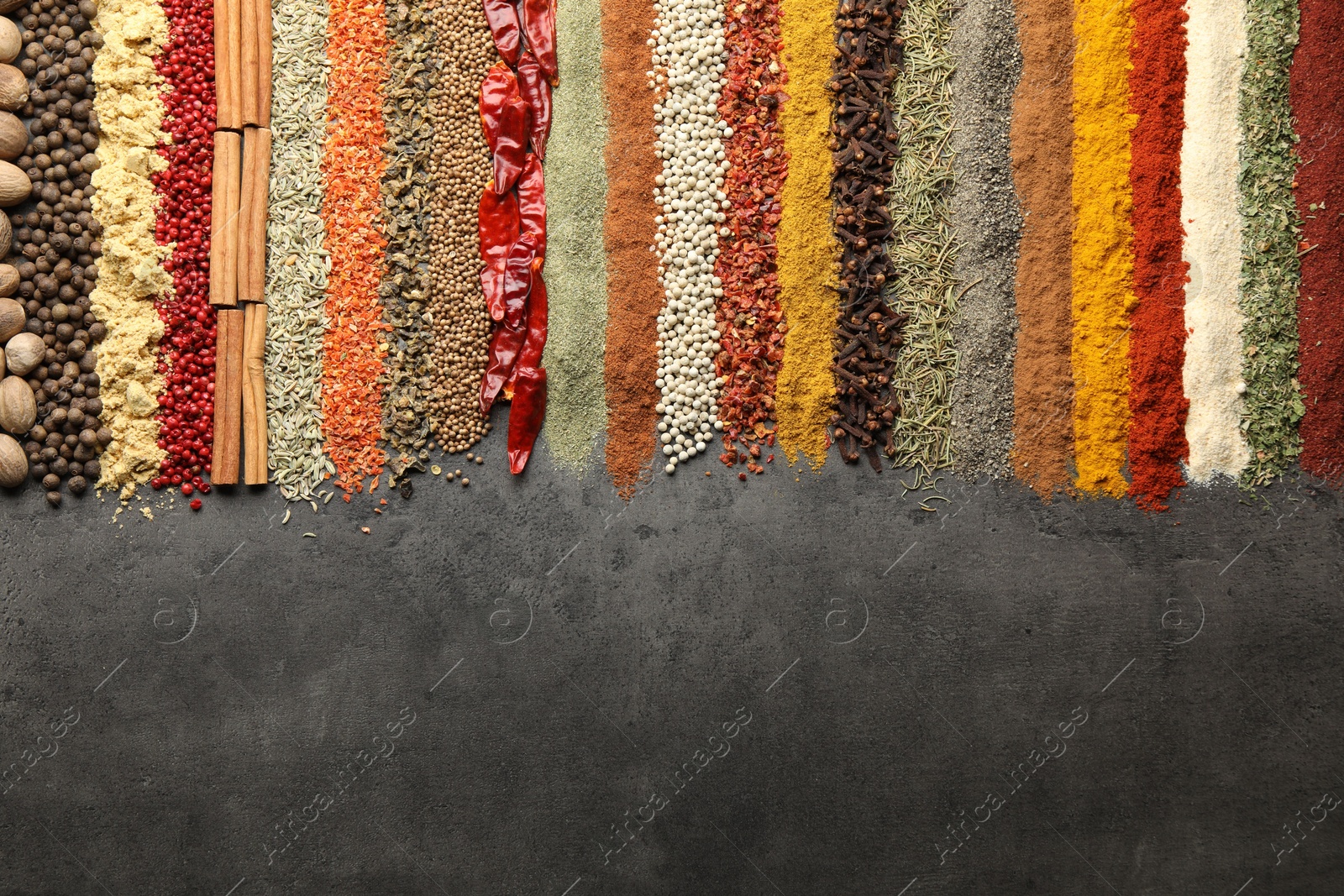 Many different spices on black table, flat lay. Space for text Photo of Many different spices on black table, flat lay. Space for text