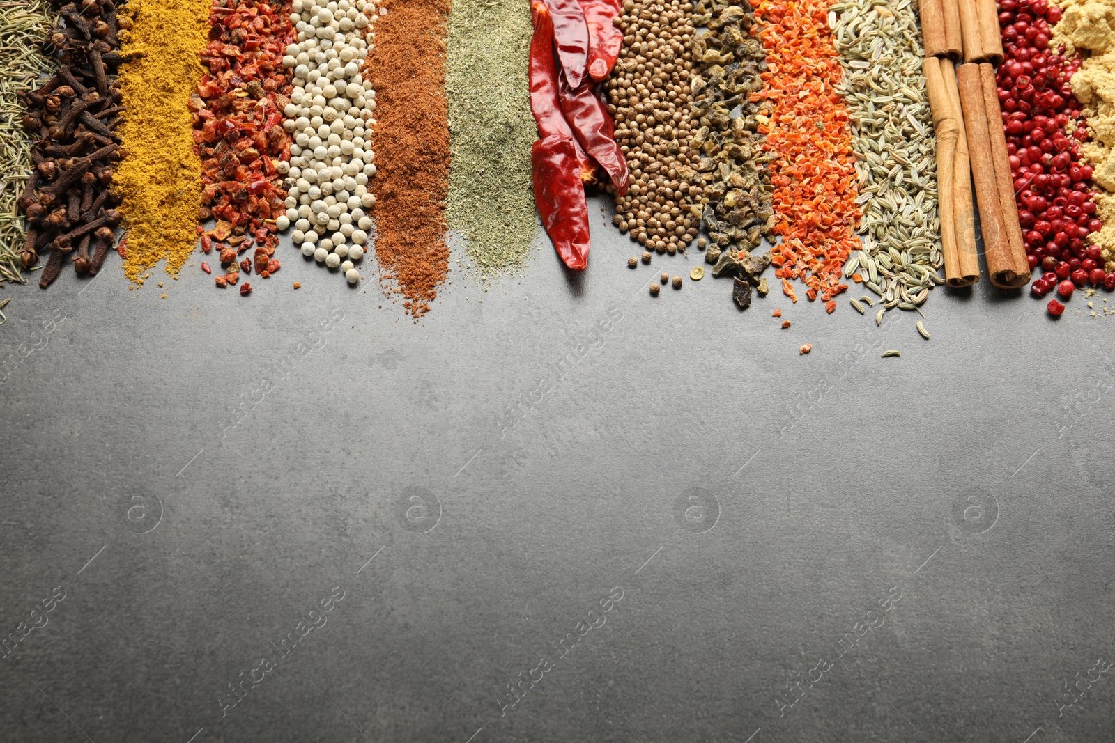 Many different spices on black table, flat lay. Space for text Photo of Many different spices on black table, flat lay. Space for text