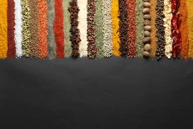 Photo of Many different spices on black table, flat lay. Space for text