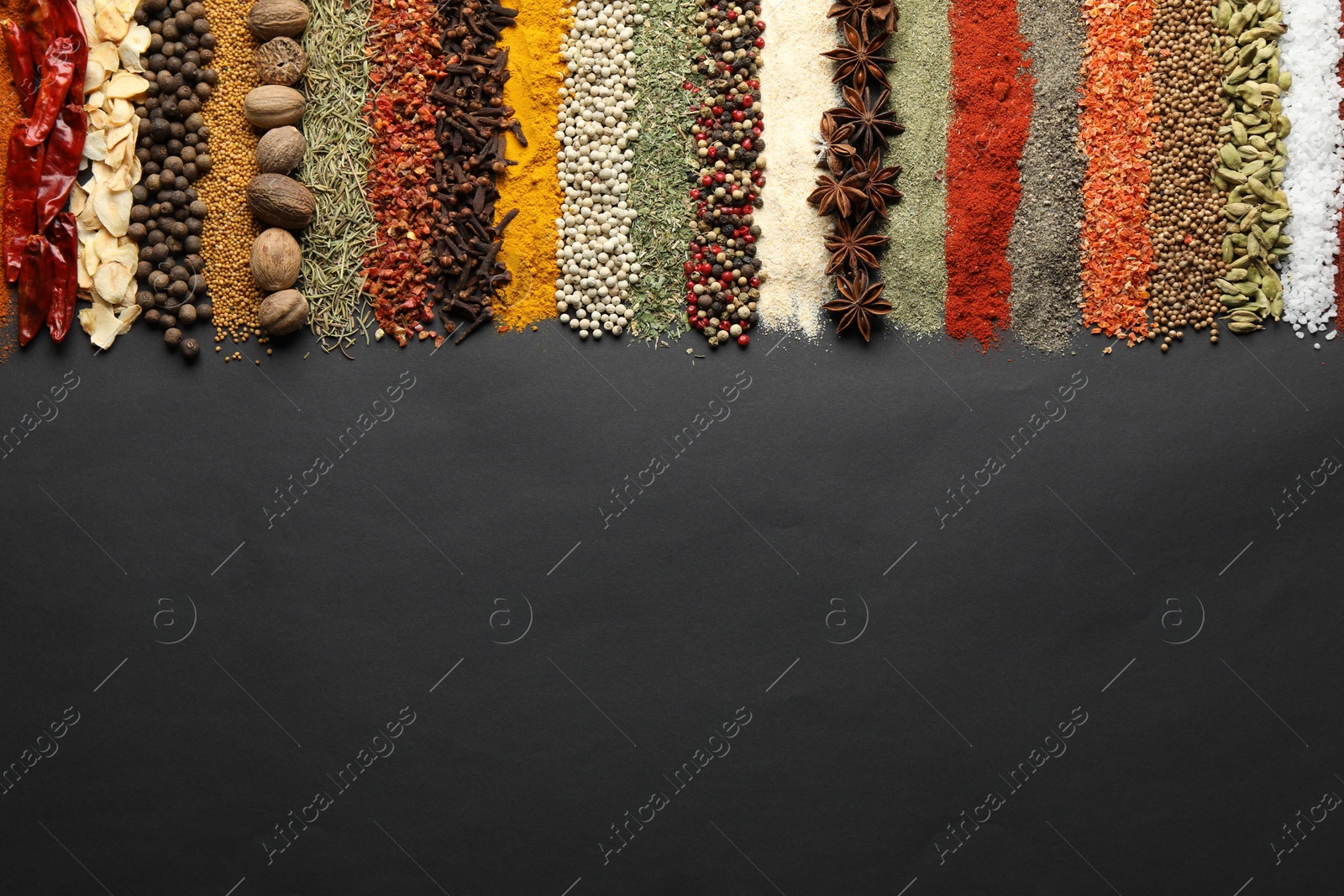 Many different spices on black table, flat lay. Space for text Photo of Many different spices on black table, flat lay. Space for text
