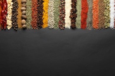 Photo of Many different spices on black table, flat lay. Space for text