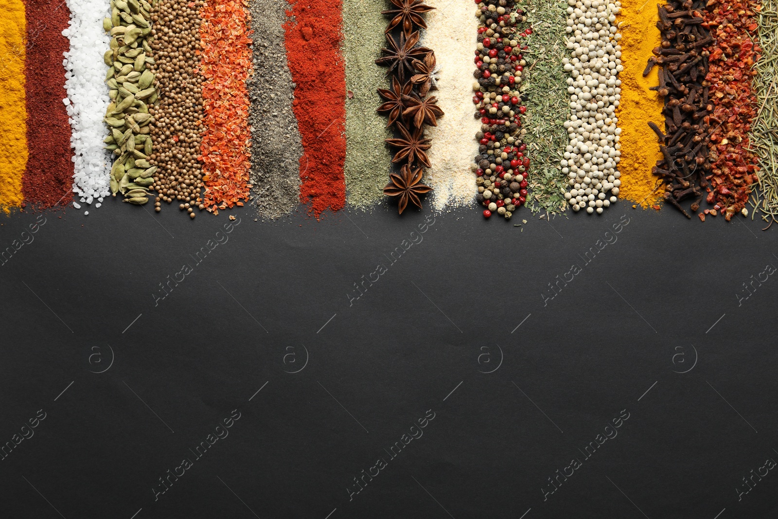 Many different spices on black table, flat lay. Space for text Photo of Many different spices on black table, flat lay. Space for text