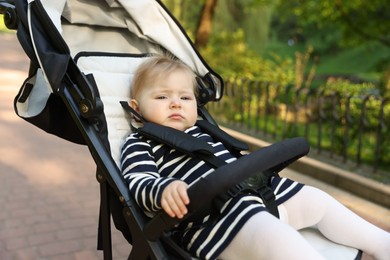 Photo of Cute little baby in stroller at park. Space for text