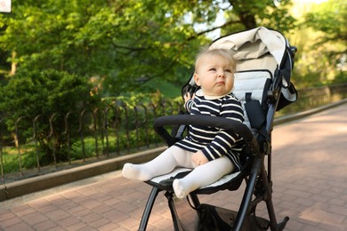 Photo of Cute little baby in stroller at park. Space for text