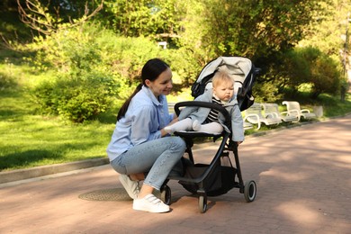 Photo of Mother with her cute baby in stroller at park