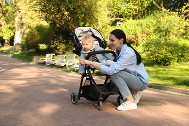 Photo of Mother with her cute baby in stroller at park