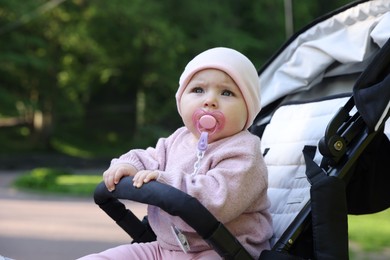Photo of Cute little baby in stroller at park. Space for text