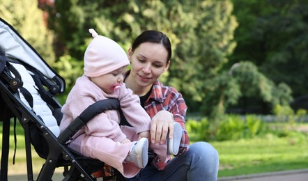 Photo of Mother with her cute baby in stroller at park