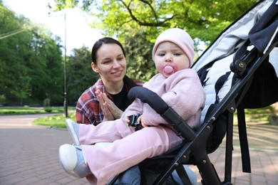 Photo of Mother with her cute baby in stroller at park