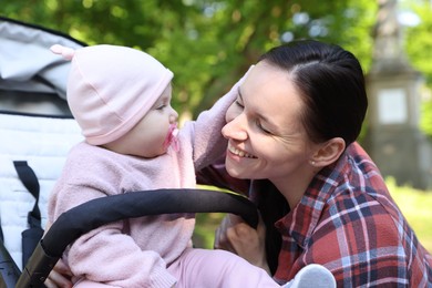 Photo of Mother with her cute baby in stroller at park