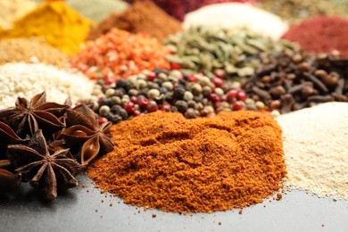 Photo of Different aromatic spices on grey table, closeup