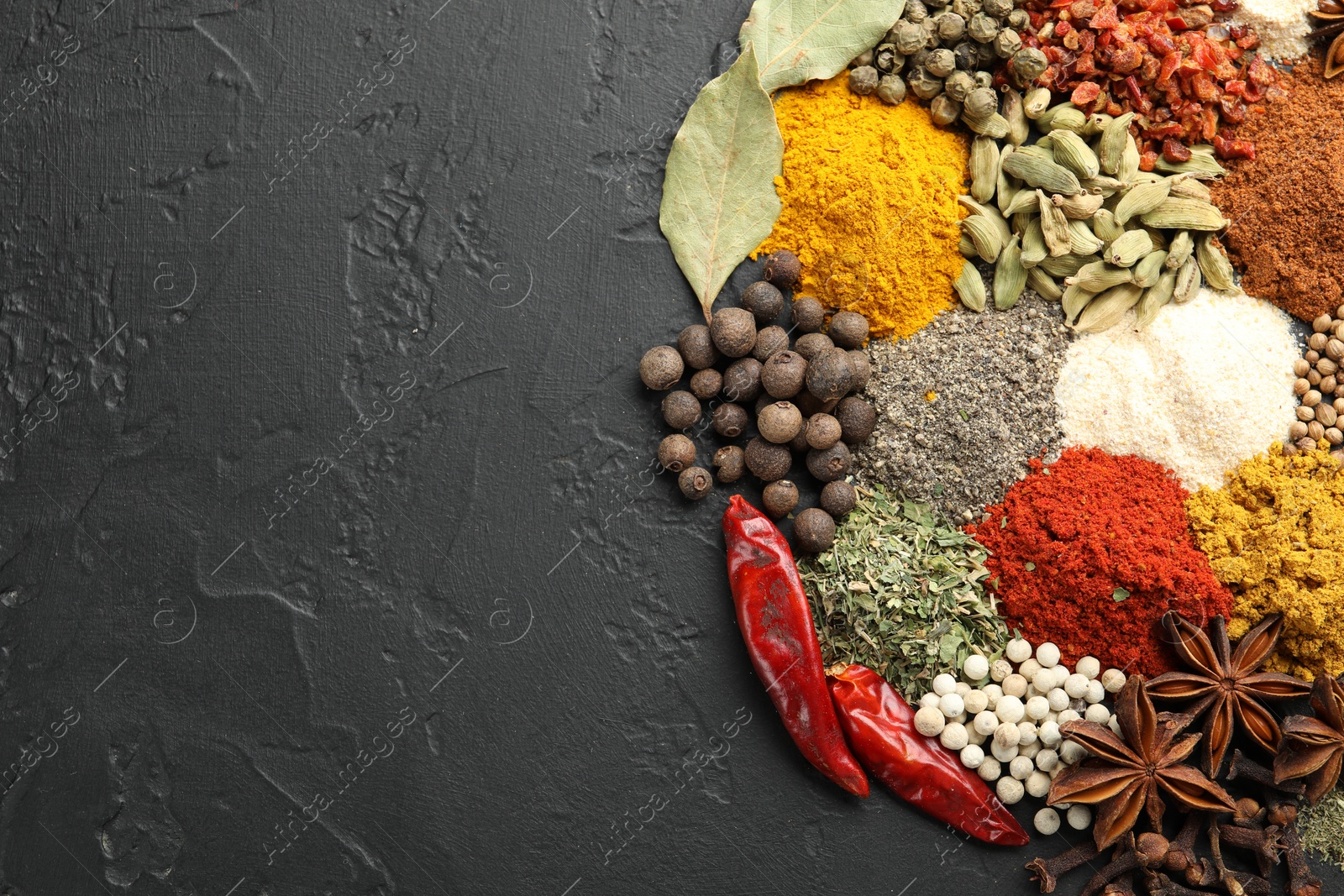 Different aromatic spices on grey table, top view. Space for text Photo of Different aromatic spices on grey table, top view. Space for text