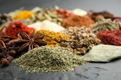 Photo of Different aromatic spices on grey table, closeup