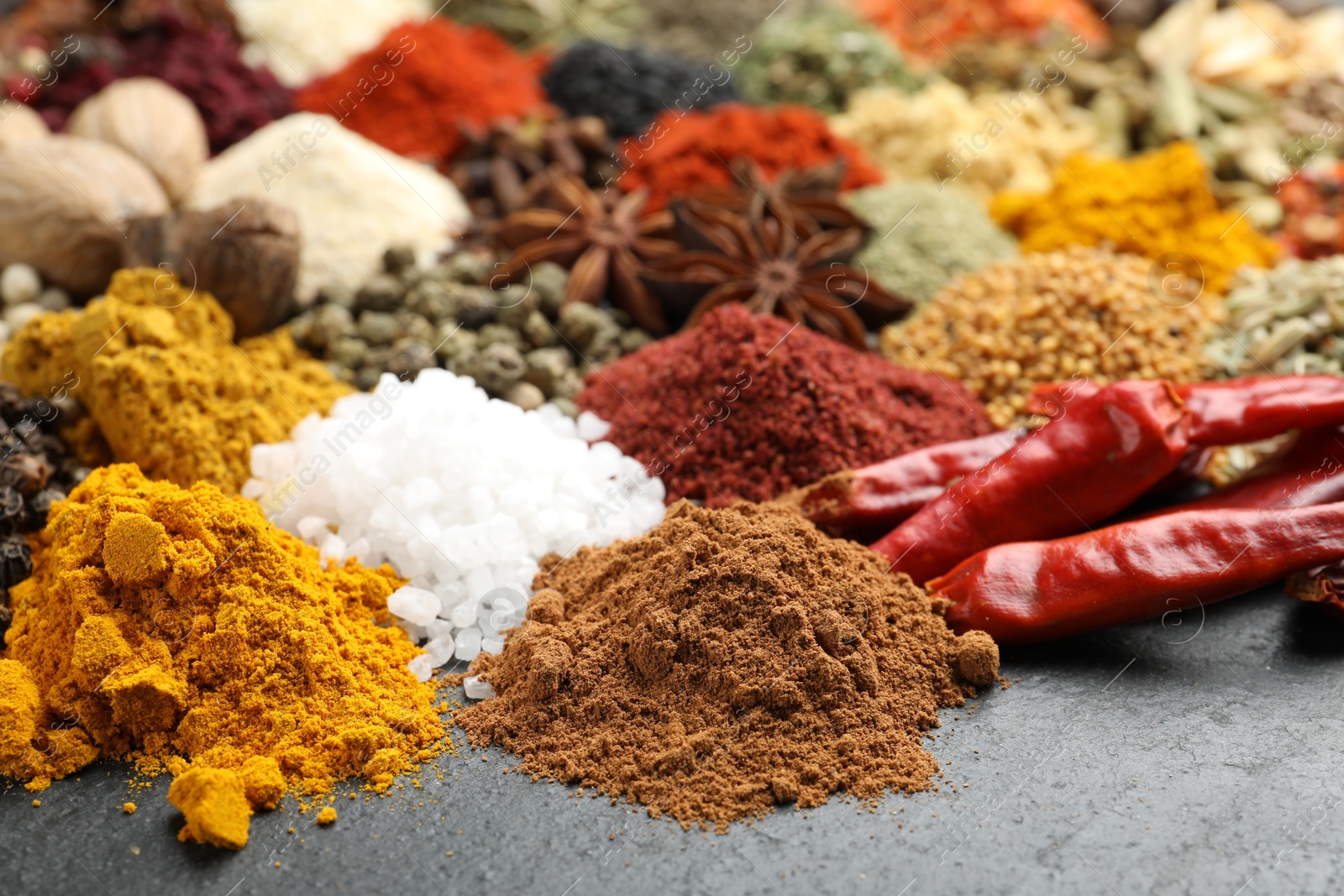 Different aromatic spices on grey table, closeup Photo of Different aromatic spices on grey table, closeup