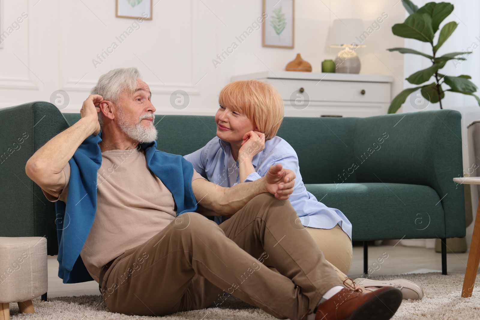 Lovely senior couple together on floor at home Photo of Lovely senior couple together on floor at home