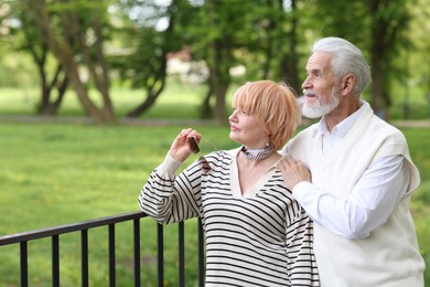 Photo of Lovely senior couple together in park, space for text