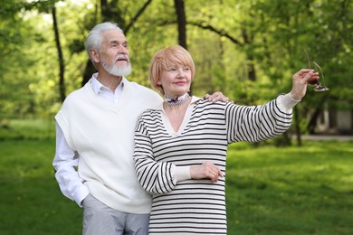 Photo of Lovely senior couple spending time together in park