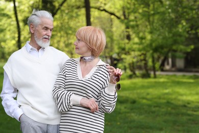 Photo of Lovely senior couple together in park, space for text