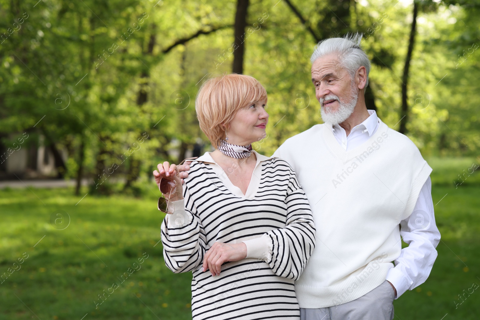 Lovely senior couple together in park, space for text Photo of Lovely senior couple together in park, space for text