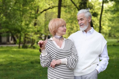 Photo of Lovely senior couple together in park, space for text
