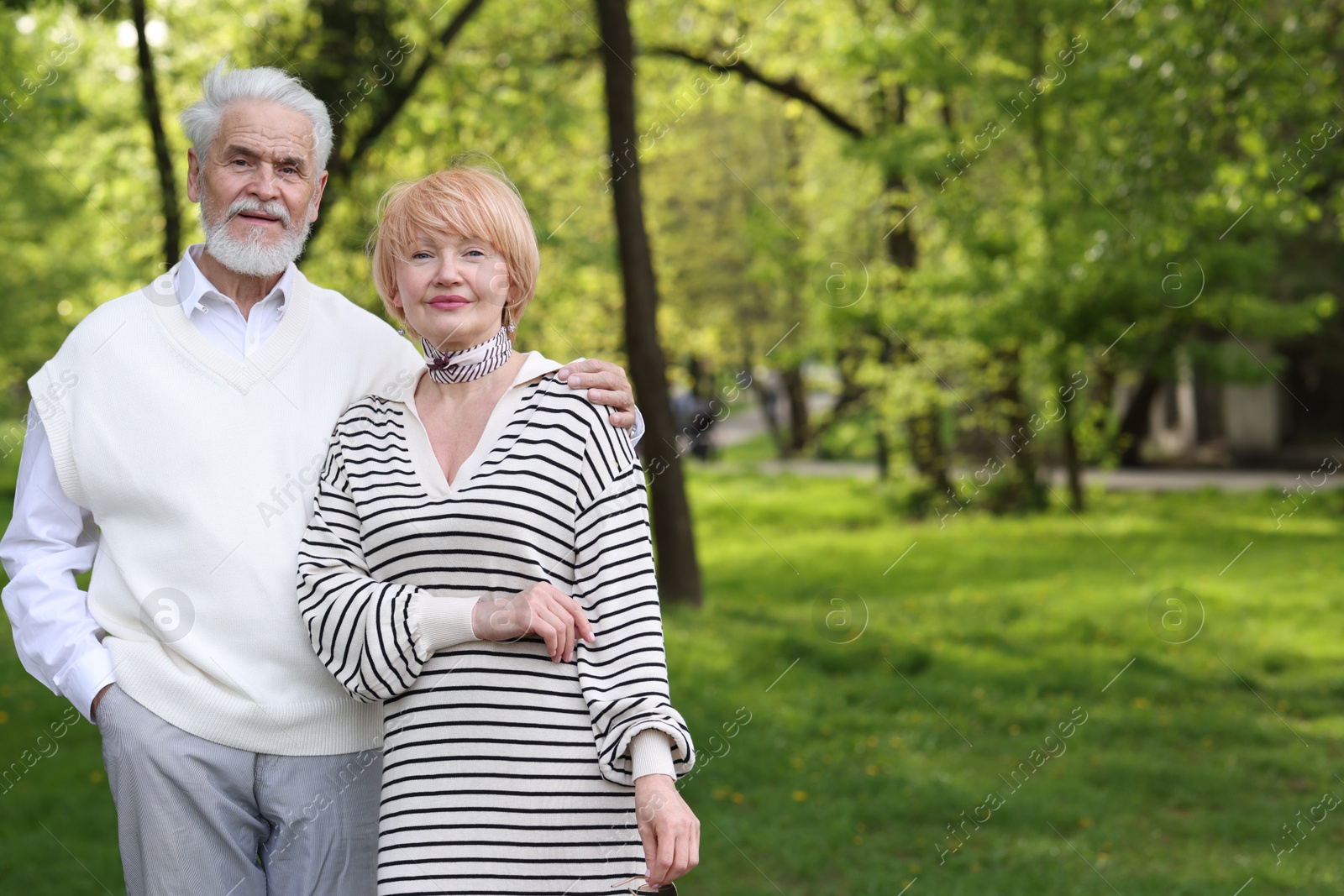 Lovely senior couple together in park, space for text Photo of Lovely senior couple together in park, space for text