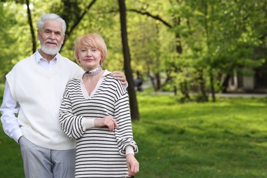 Photo of Lovely senior couple together in park, space for text