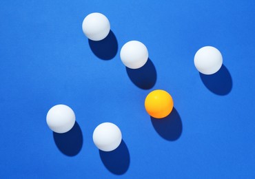 Photo of Many ping pong balls on blue background, flat lay