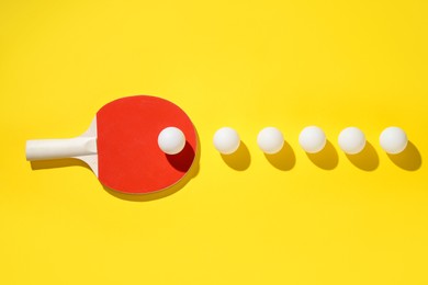 Photo of Ping pong racket and balls on yellow background, flat lay