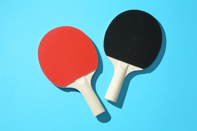 Photo of Ping pong rackets on blue background, top view