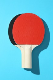 Photo of Ping pong rackets on blue background, top view