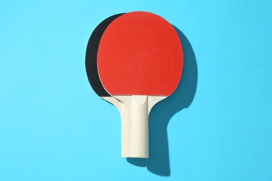 Photo of Ping pong rackets on blue background, top view