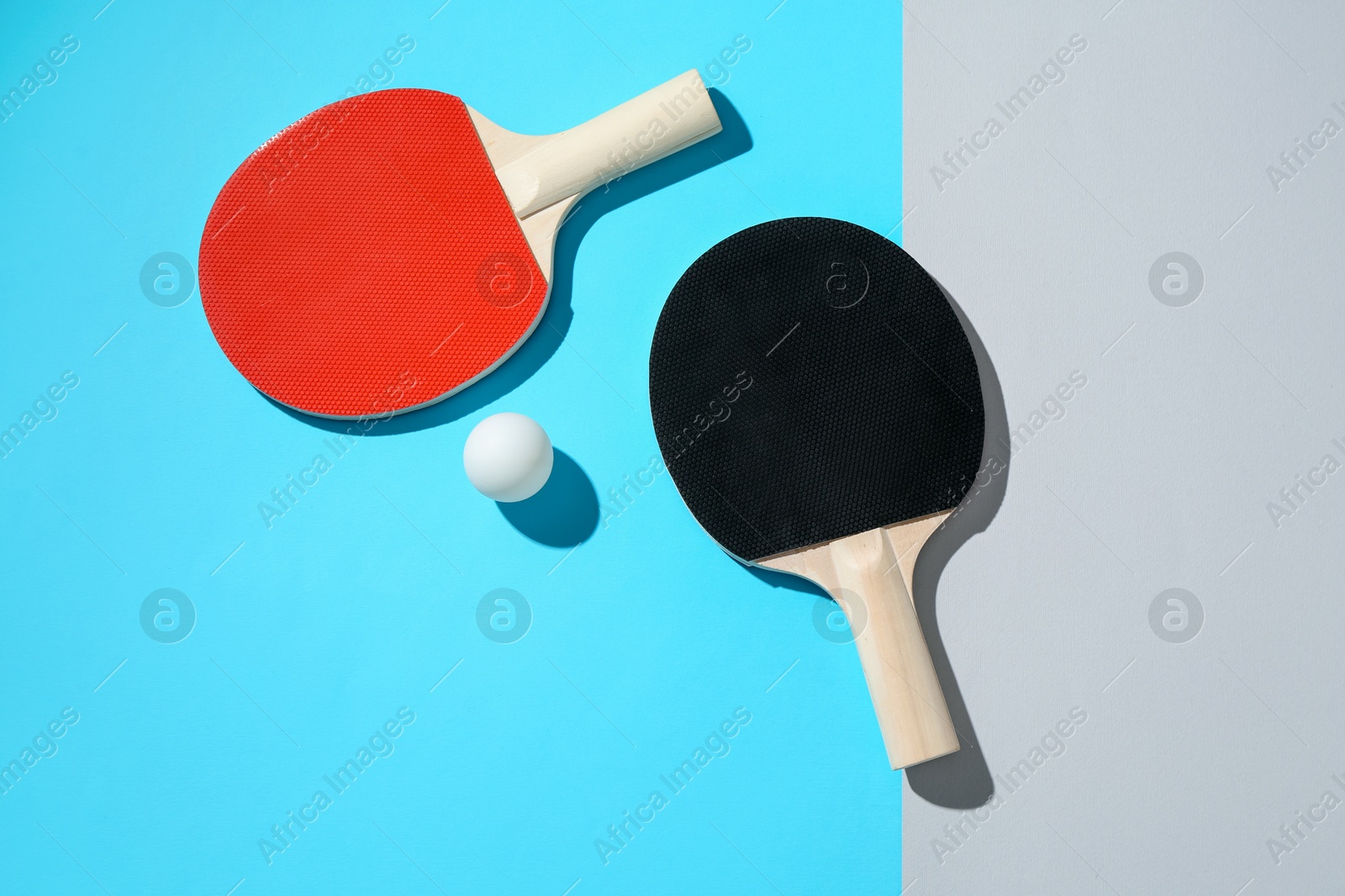 Ping pong rackets and ball on color background, top view Photo of Ping pong rackets and ball on color background, top view