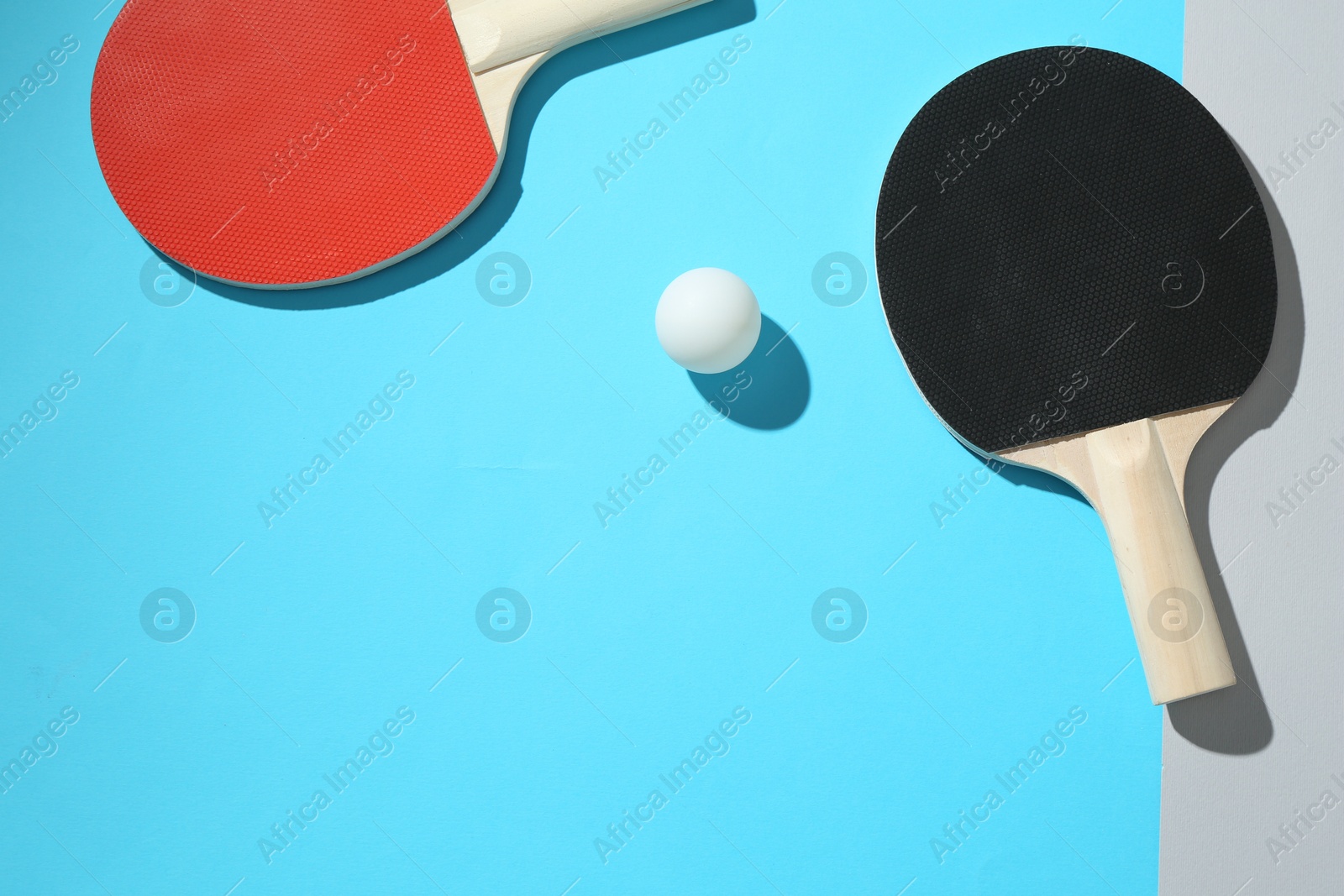 Ping pong rackets and ball on color background, top view. Space for text Photo of Ping pong rackets and ball on color background, top view. Space for text