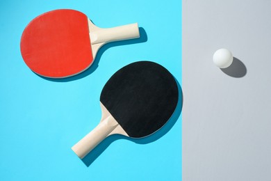 Photo of Ping pong rackets and ball on color background, top view