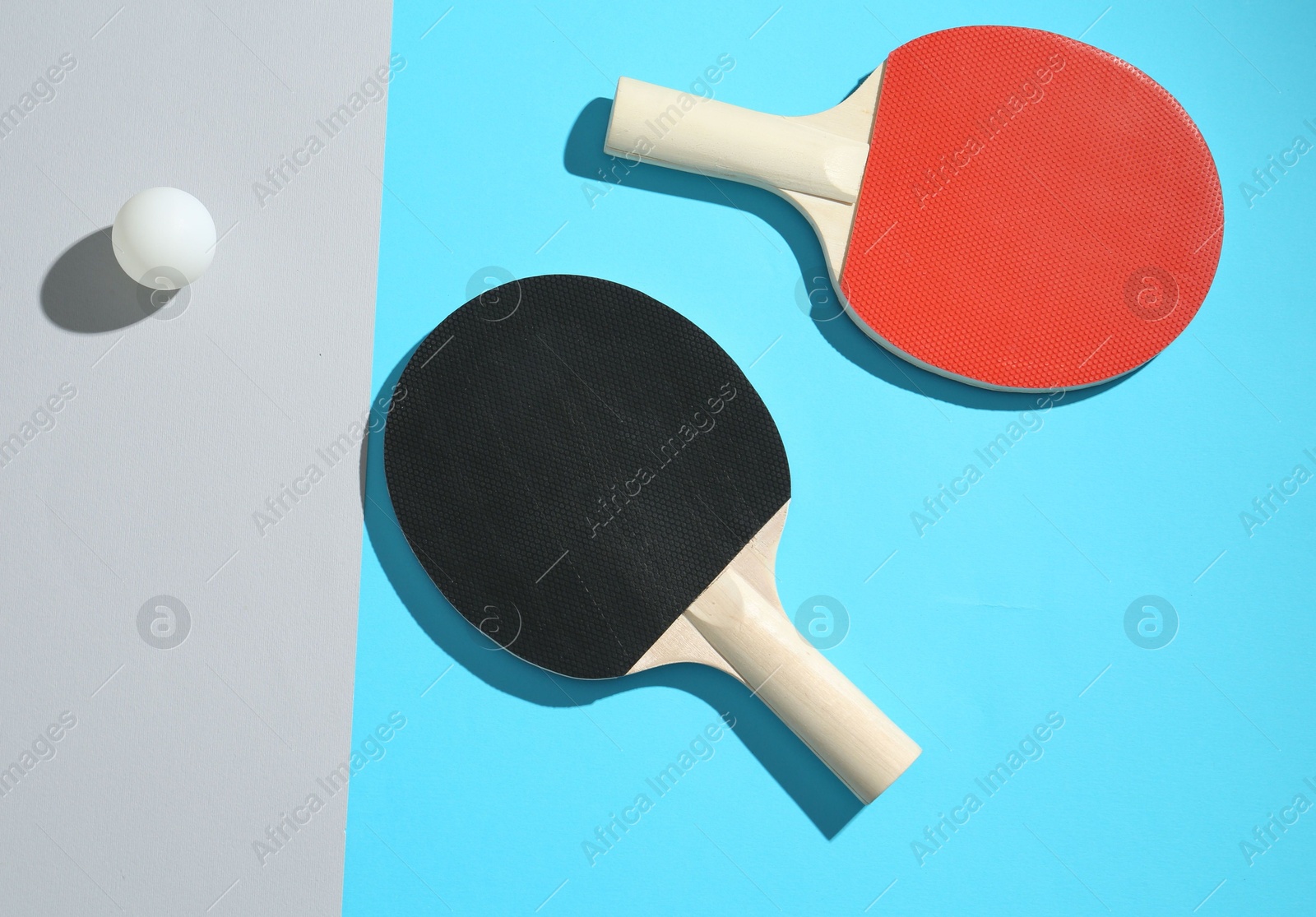 Ping pong rackets and ball on color background, top view Photo of Ping pong rackets and ball on color background, top view