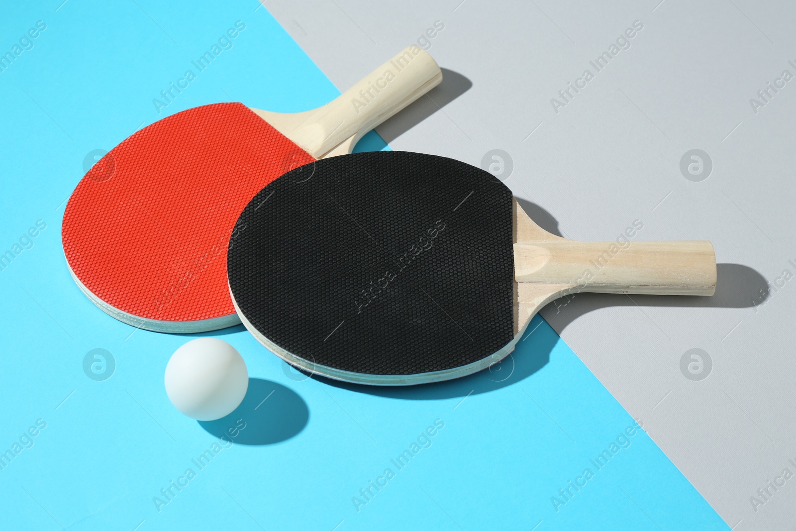 Ping pong rackets and ball on color background Photo of Ping pong rackets and ball on color background
