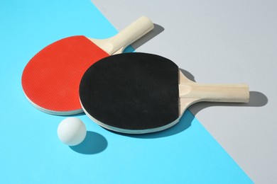 Photo of Ping pong rackets and ball on color background