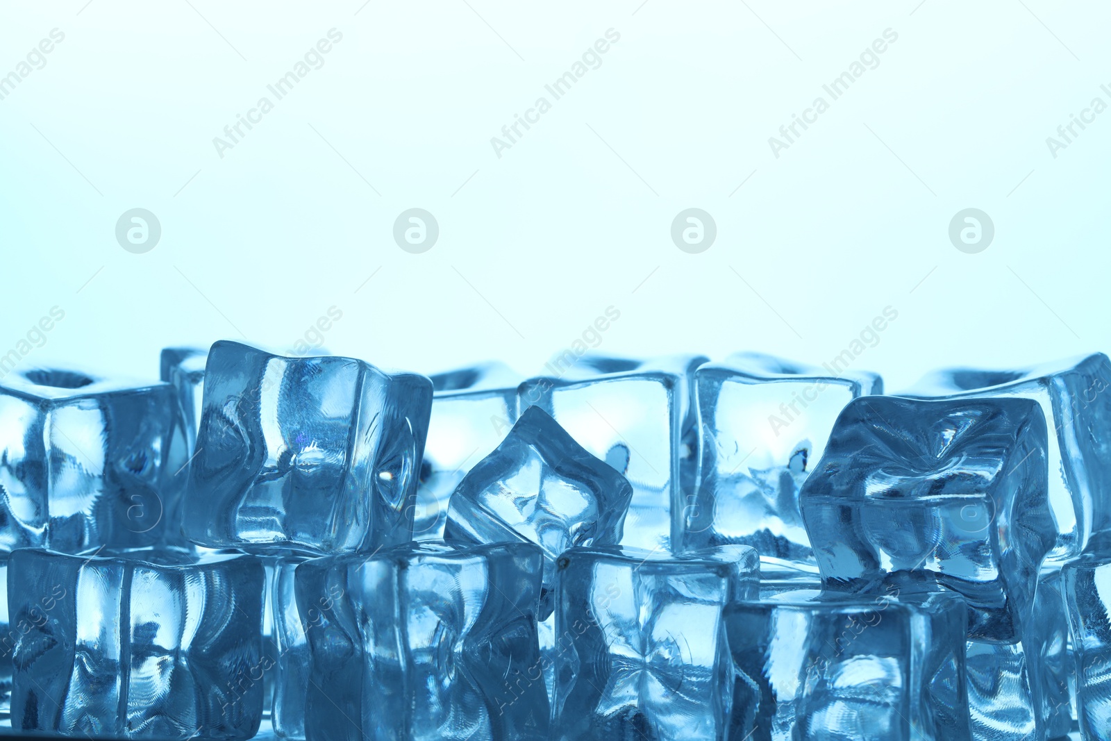 Many ice cubes on light background, closeup. Space for text Photo of Many ice cubes on light background, closeup. Space for text