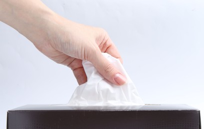 Photo of Woman taking handkerchief out of box on white background, closeup