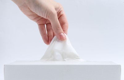 Photo of Woman taking handkerchief out of box on white background, closeup