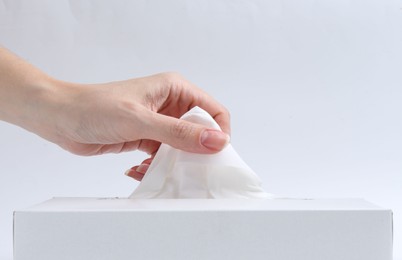 Photo of Woman taking handkerchief out of box on white background, closeup