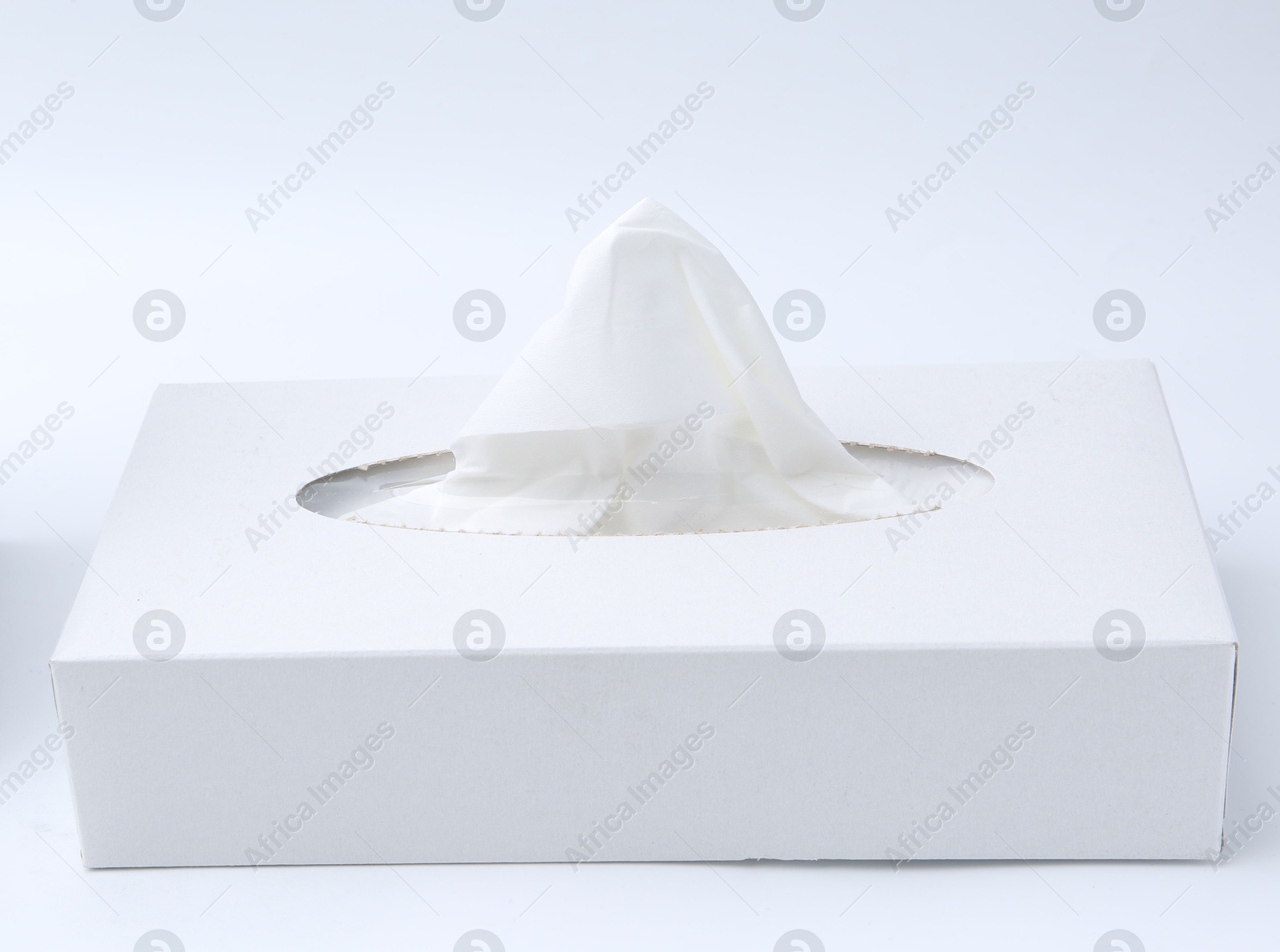 Box with paper handkerchiefs on white background Photo of Box with paper handkerchiefs on white background