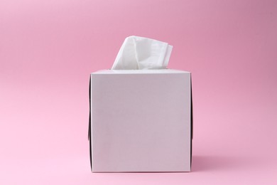 Photo of Box with paper handkerchiefs on pink background