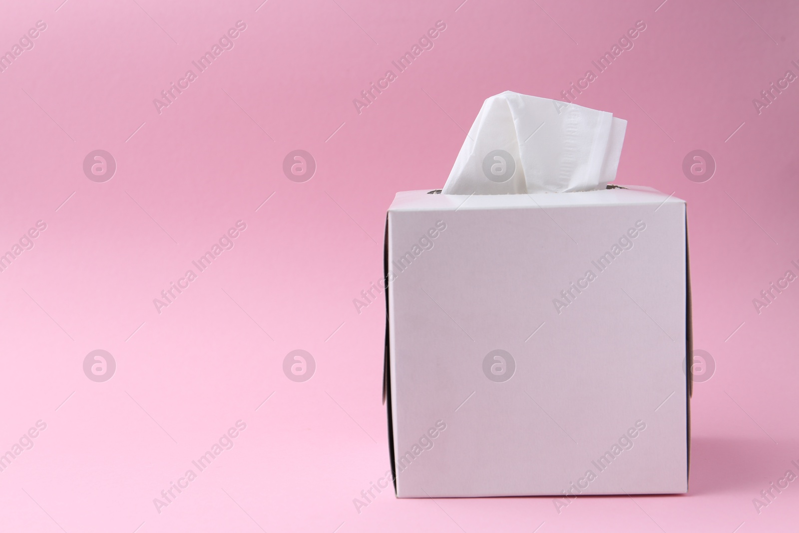 Box with paper handkerchiefs on pink background. Space for text Photo of Box with paper handkerchiefs on pink background. Space for text